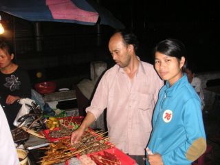 Xiao Wei bij een foodcourt (eetplein) op straat.